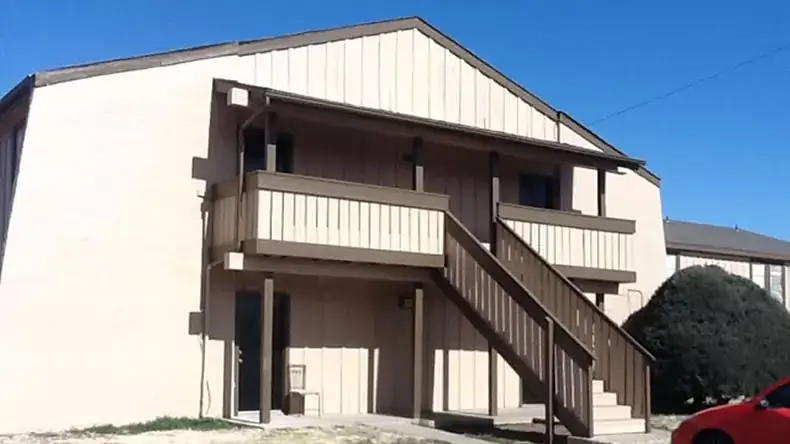 Exterior of a two-story multifamily building with reconstructed stairs and balcony railings
